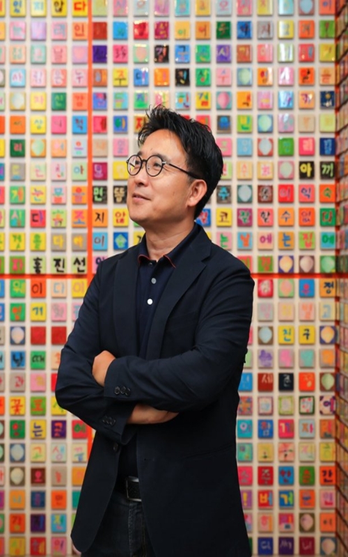 Artist Ik-Joong Kang with his 3 X 3-inch Hangeul canvases.