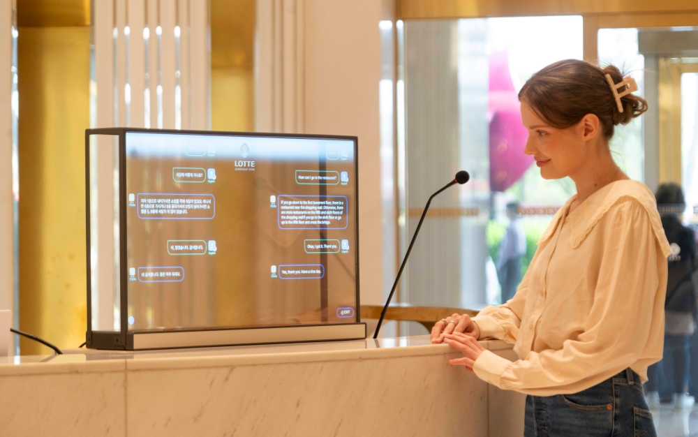 A customer uses Trans Talker, an artificial intelligence interpretation service for foreign shoppers, at the Lotte Department Store branch in Seoul's Songpa-gu District. (SK Telecom) 