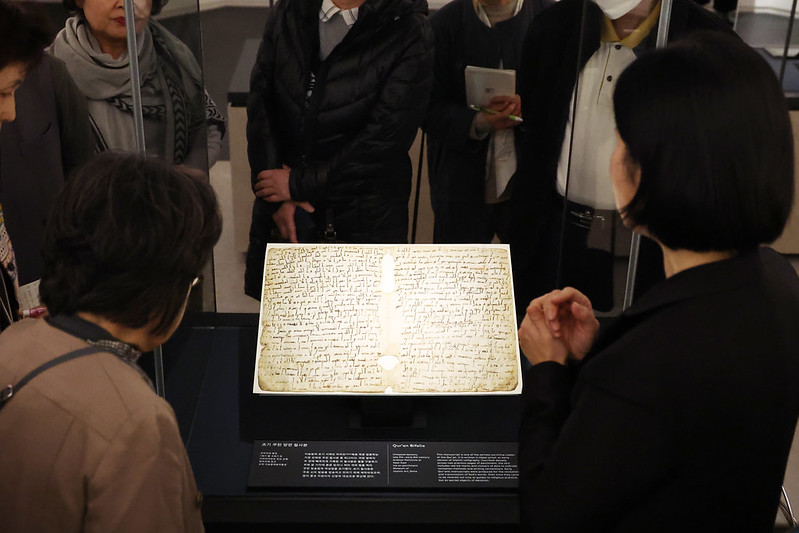 Visitors at a media preview of the National Museum of Korea's permanent Islamic Art Gallery, which opened on Nov. 21, look at a Quran bifolio, one of the world's oldest surviving manuscripts of Islam's holy book believed to date back to the late seventh to early eighth centuries. The relic is considered an important resource for understanding the calligraphy and binding methods used before the advent of Islamic manuscript culture.