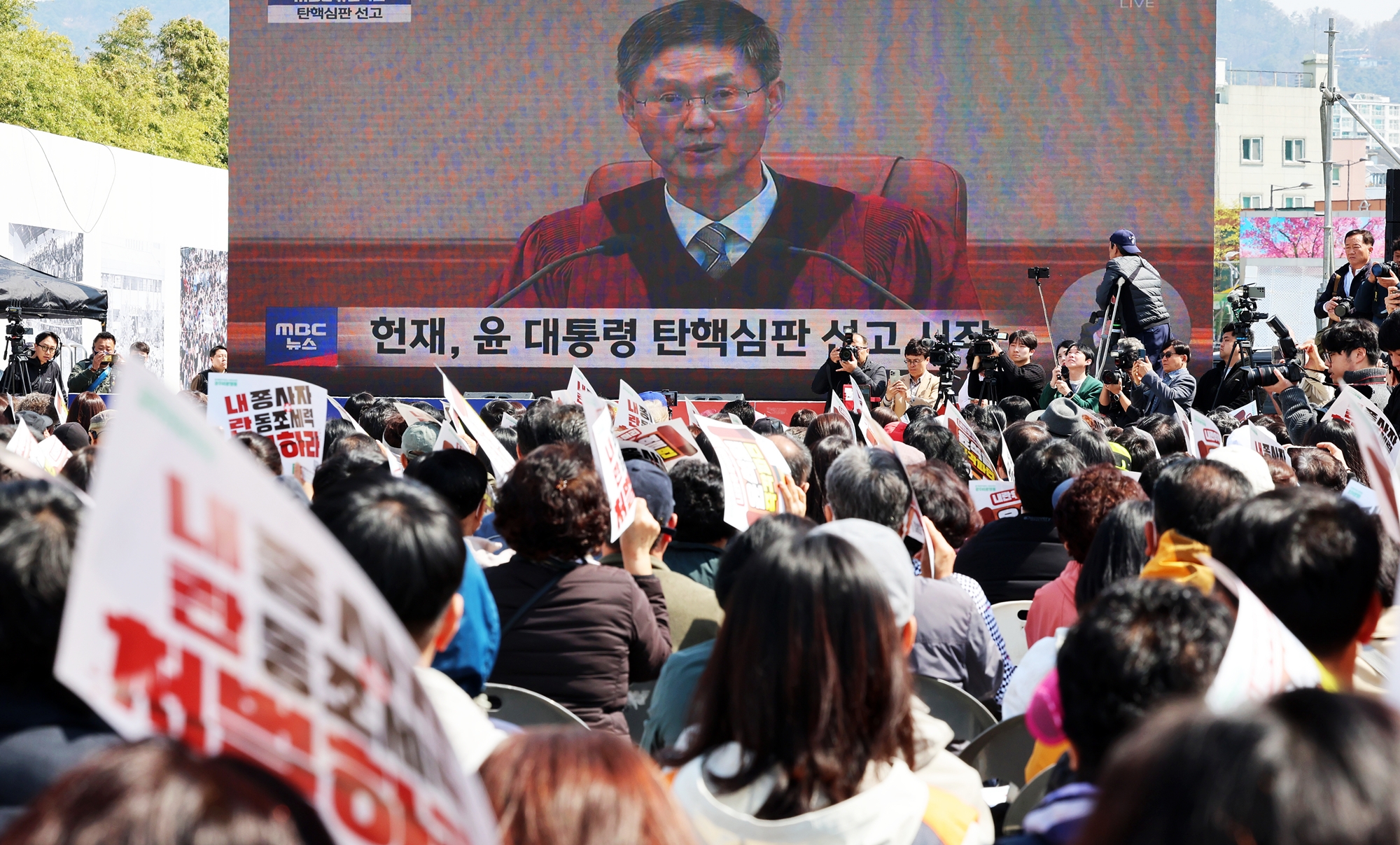 Crowds on the morning of April 4 gather to watch a live broadcast of the Constitutional Court's ruling on the impeachment motion against President Yoon Suk Yeol at May 18 Democracy Square in Gwangju's Dong-gu District. 
