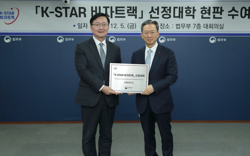 Minister of Justice Jung Sung-ho (right) on Dec. 5 presents a plaque to Seoul National University President Ryu Hong Rim on the designation of the latter's school for the K-Star Visa Track at Government Complex-Gwacheon in Gwacheon, Gyeonggi-do Province. (Ministry of Justice)