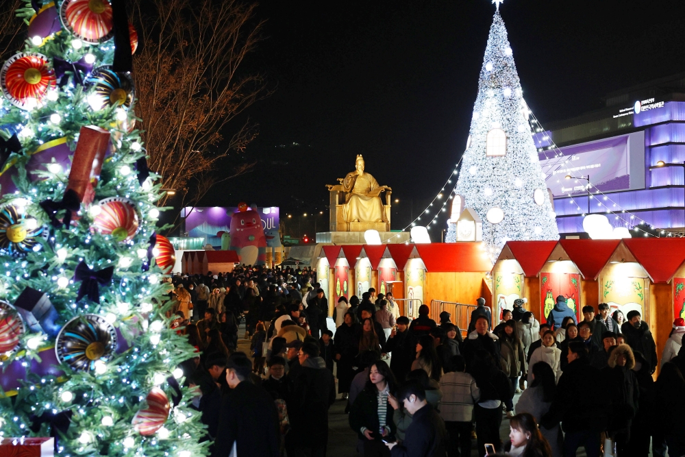 Visitors at the annual Seoul Winter Festa on Dec. 14 look around the Christmas-themed Gwanghwamun Market at Gwanghwamun Square in Seoul's Jongno-gu District.