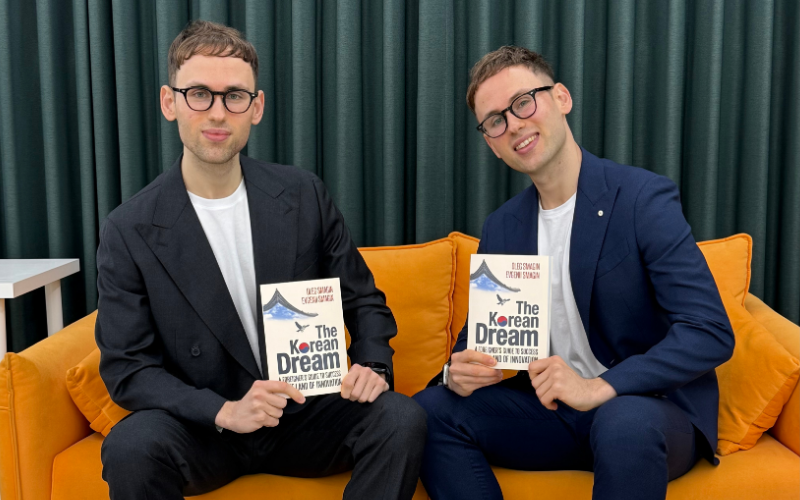 Brothers Oleg and Evgenii Smagin pictured holding their book “The Korean Dream.”
