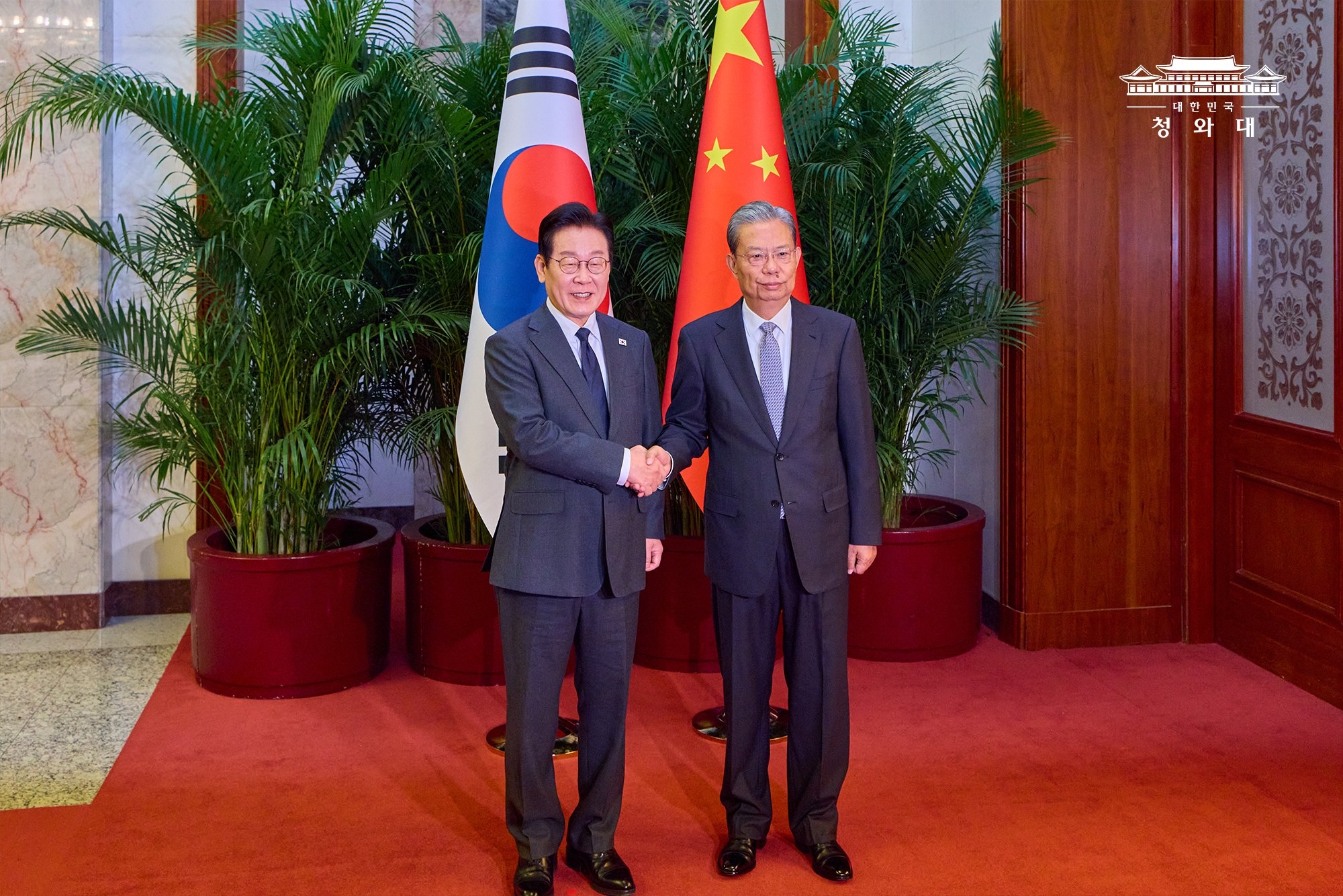 President Lee Jae Myung (left) on Jan. 6 takes a photo with Zhao Leji, chairman of the Standing Committee of the National People's Congress, at the Great Hall of the People in Beijing.  
