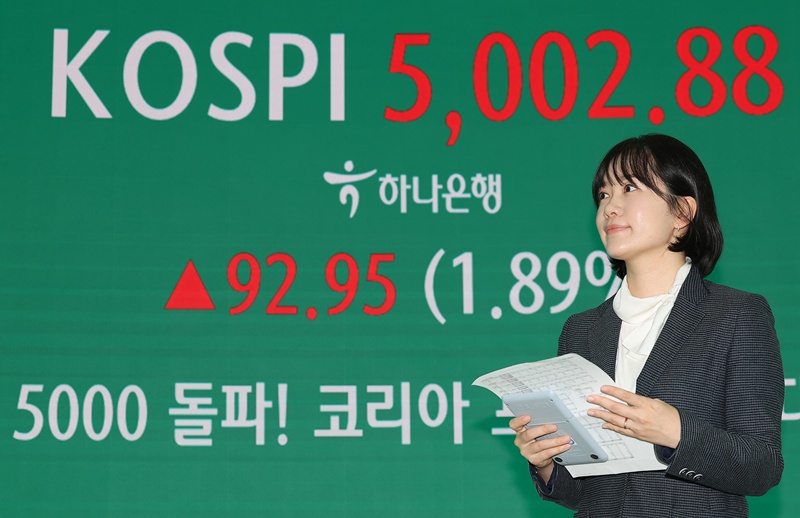 An electronic bulletin board on Jan. 22 displays news of the main stock market KOSPI breaking 5,000 for the first time at the dealing room of Hana Bank headquarters in Seoul's Jung-gu District. (Yonhap News)