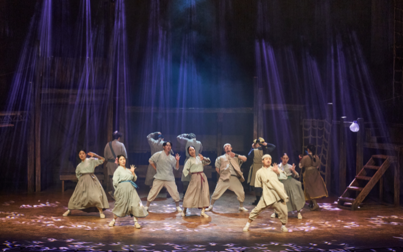 Performers dancing on stage in the musical 