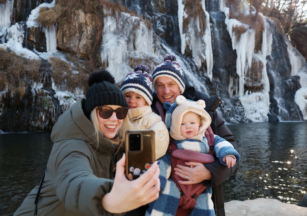 The limit for prepaid cards exclusively for foreign visitors to Korea has been doubled to KRW 1 million. Shown is a family taking photos on Jan. 7 at Hongjecheon Artificial Waterfall in Seoul's Seodaemun-gu District. (Lee Jeongwoo)  