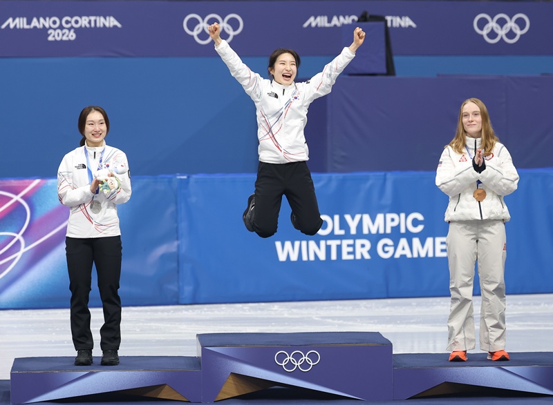 Kim Gilli (center) on Feb. 20 at the Milano Ice Skating Arena in Milan jumps to celebrate her gold medal in the women's 1,500-m short track at the Milan Cortina Winter Olympics in Italy with runner-up compatriot Choi Minjeong (left) and bronze medalist Corinne Stoddard of the U.S. (Yonhap News)  