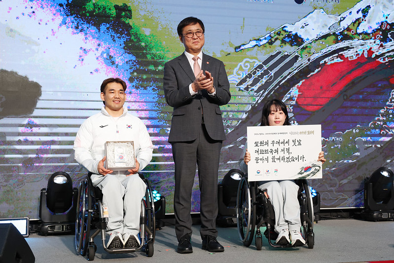 Minister of Culture, Sports and Tourism Chae Hwi-young (center) on Feb. 2 poses for photos with Lee Yong-seok (left), a member of the wheelchair curling mixed doubles team, and Nordic skier Kim Yun-ji at the athletes' launch ceremony for the Milan Cortina Winter Paralympics at Olympia Hall of Olympic Parktel in Seoul's Songpa-gu District. (Lee Jeongwoo) 