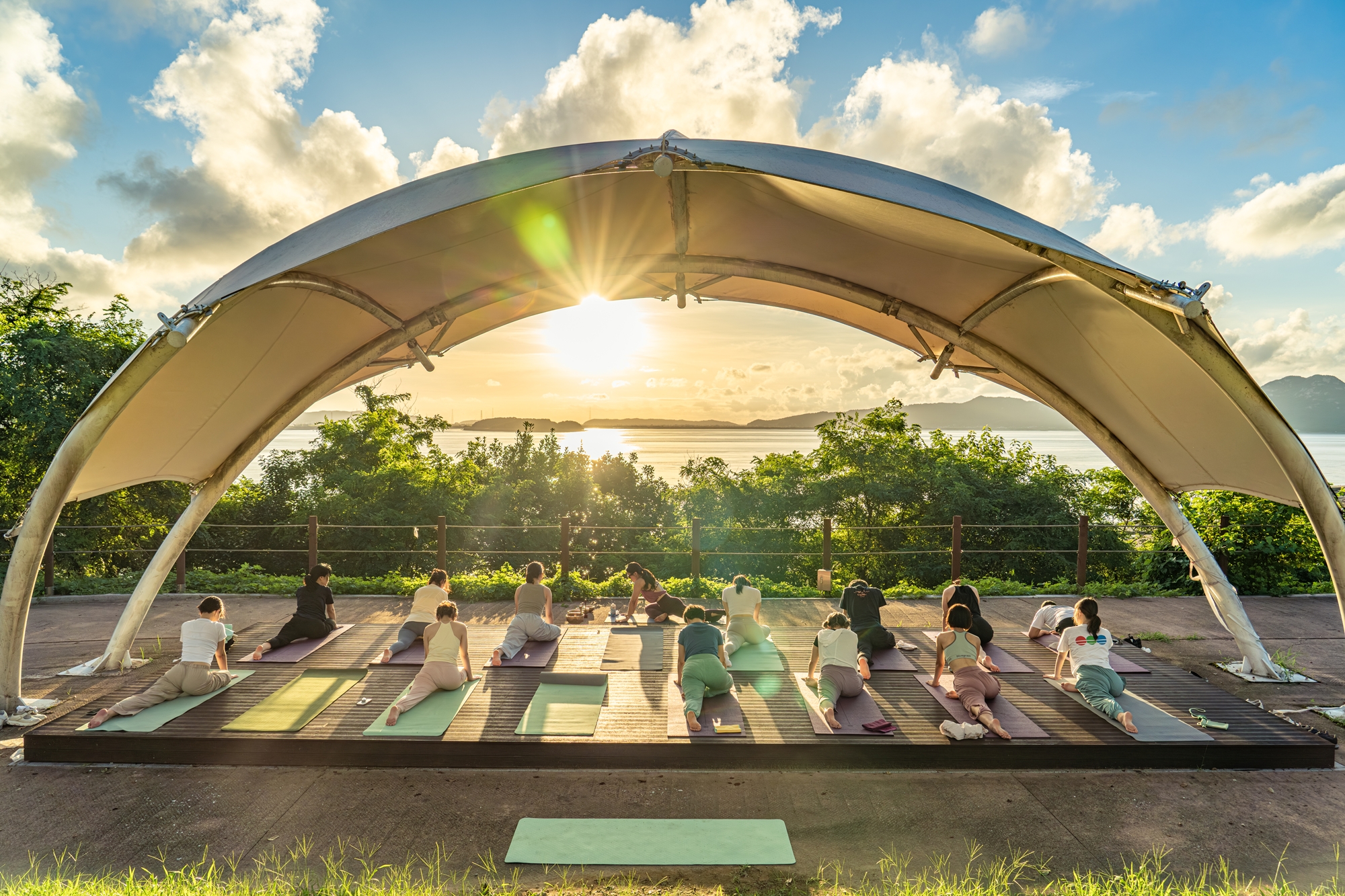 Participants in the Rest a While Island Project practice yoga while facing the sunset on Ganghwado Island of Incheon. (Korea Tourism Organization)