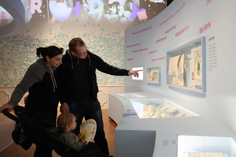 A family on April 7 looks at the nation's past and present baby carriers at the exhibition 