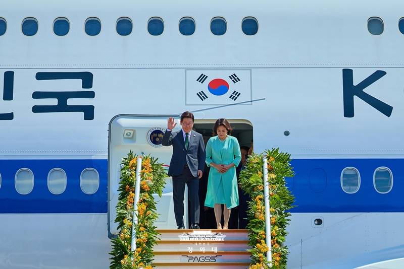 President Lee Jae Myung (left) and first lady Kim Hea Kyung on March 3 greet onlookers after arriving at Villamor Air Base in the Philippines. (Cheong Wa Dae)  
