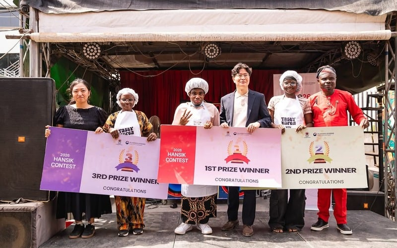 (from left to right) Event manager and interpreter Lee Yun Jin, third place winner Favour Dajibesh, first place winner Victor Mac-adonai, KCCN Director Jeon Ju Ho, second place winner Oluwasegun Faith and a Nigerian culinary expert Godfrey Mario pose for a photo after the grand finale of the 2026 Hansik Cooking Contest held in Abuja, Nigeria, on March 28, 2026. (KCCN)