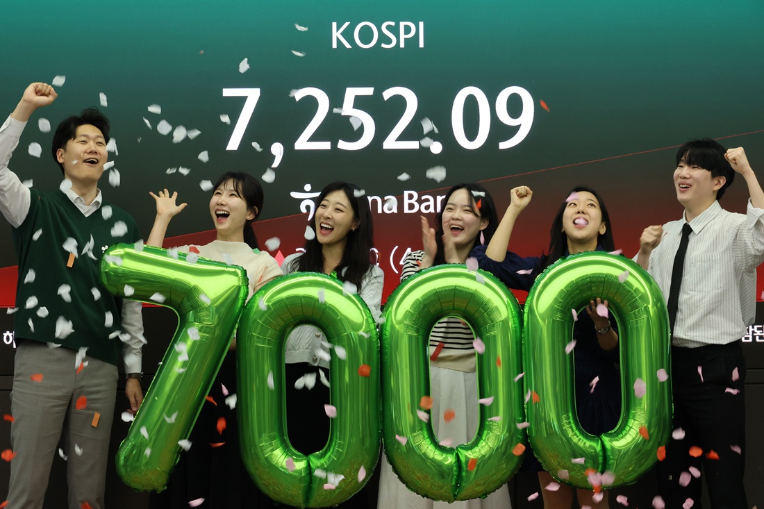 Staff at the trading room of Hana Bank headquarters in Seoul's Jung-gu District on May 6 hold a ceremony celebrating the main stock market index KOSPI breaking 7,000 for the first time. (Yonhap News)  