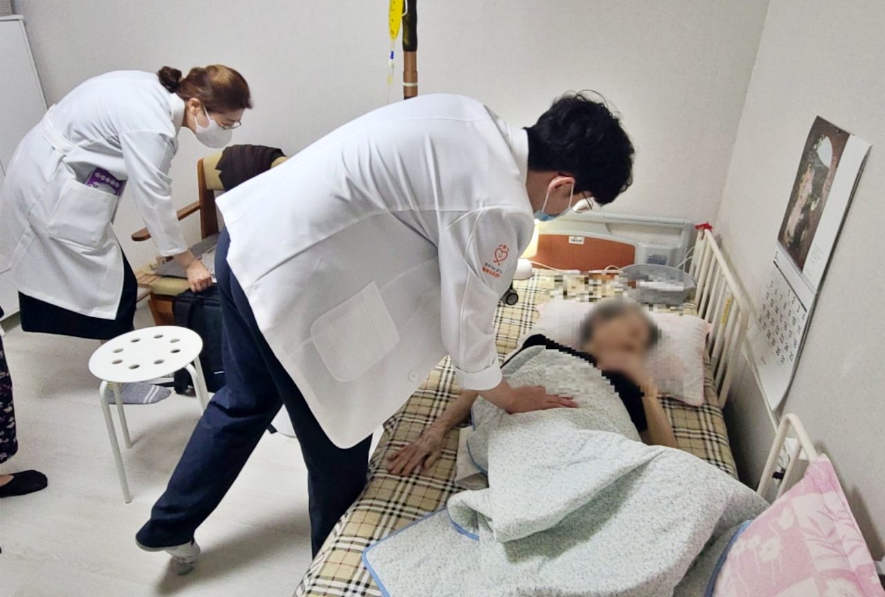 Staff from Gyeonggi-do Province's visiting medical care center treat a patient at her home. (Gyeonggi Provincial Office)