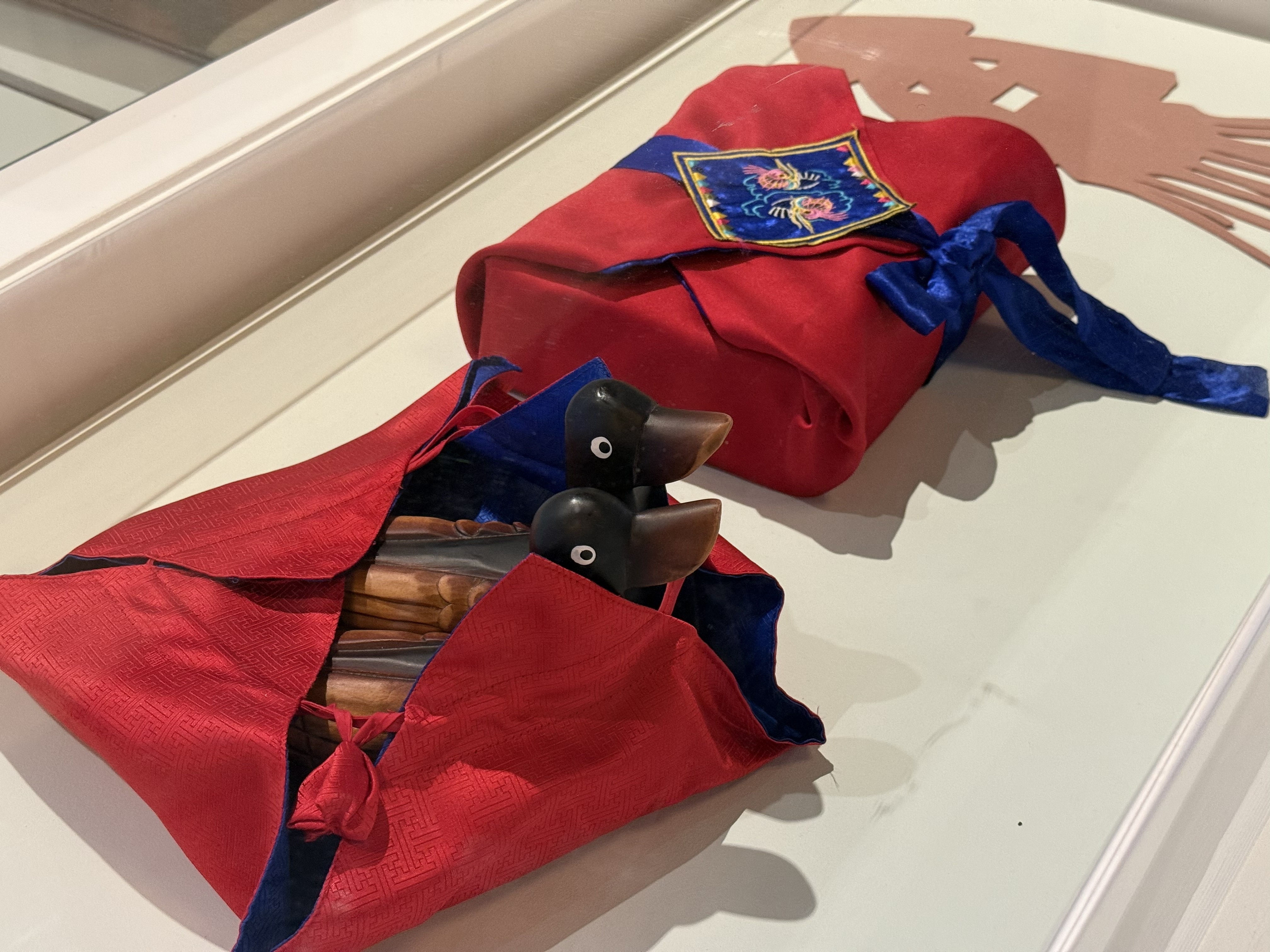 Pair of traditional wooden geese wrapped in blue and red cloth