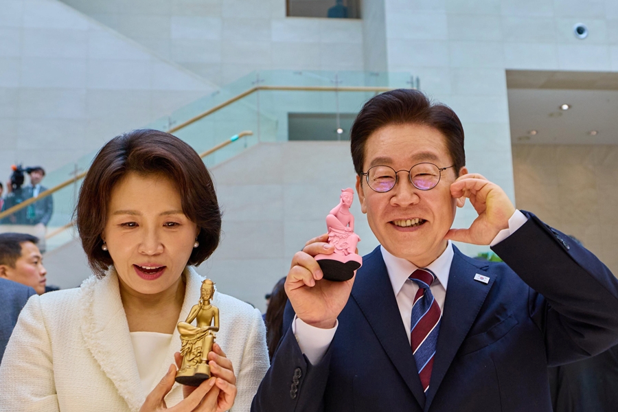 President Lee Jae Myung (right) and first lady Kim Hea Kyung on Feb. 26 hold souvenirs at a gift store after visiting the exhibition 