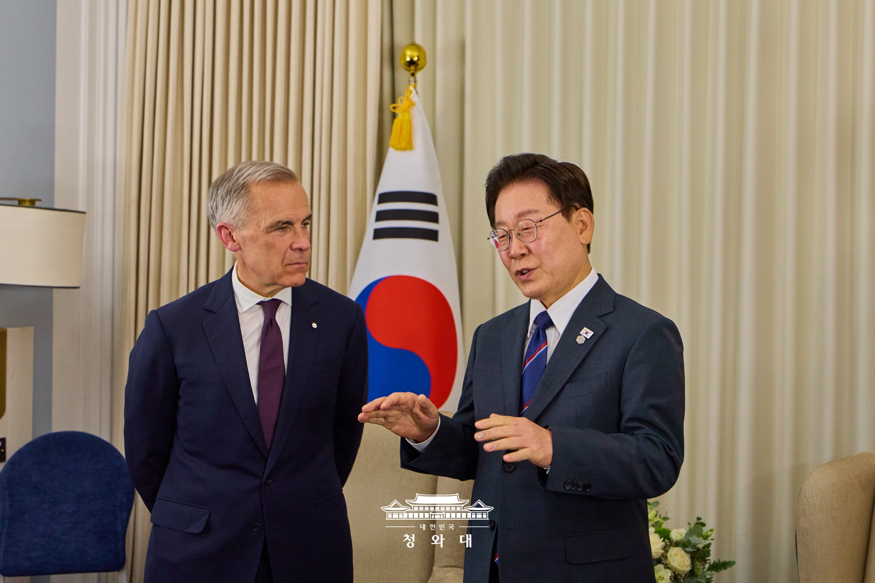 President Lee Jae Myung (right) on June 16 speaks to Canadian Prime Minister Mark Carney in their bilateral summit at the G7 summit in the French resort town of Evian-les-Bains.