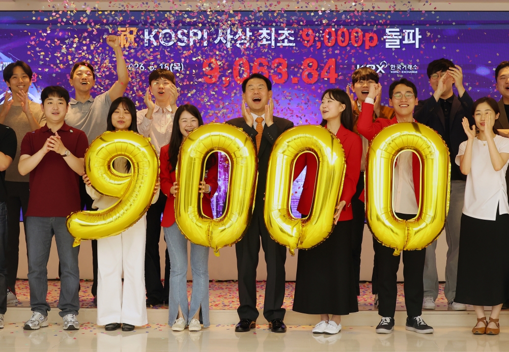The main stock market KOSPI has surpassed 9,000 for the first time. Staff at Korea Exchange headquarters in Busan's Nam-gu District on June 18 posing for a photo at a celebratory ceremony. (Yonhap News)