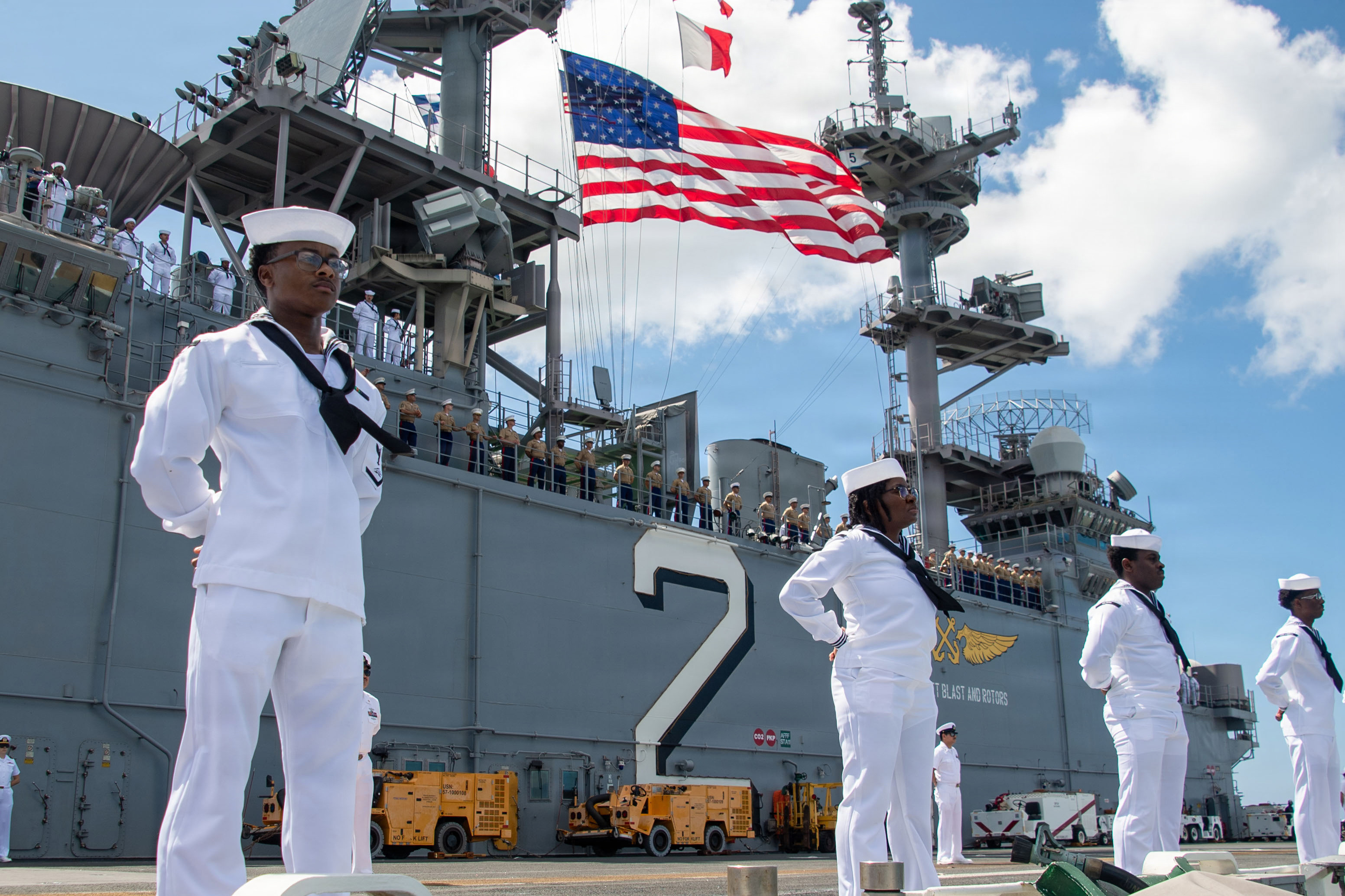 U.S. Navy and Marine personnel on June 21 line up on the amphibious assault ship USS Essex as it arrives at the port of Pearl Harbor, Hawaii, to participate in the Rim of the Pacific exercise. (U.S. Department of War)  