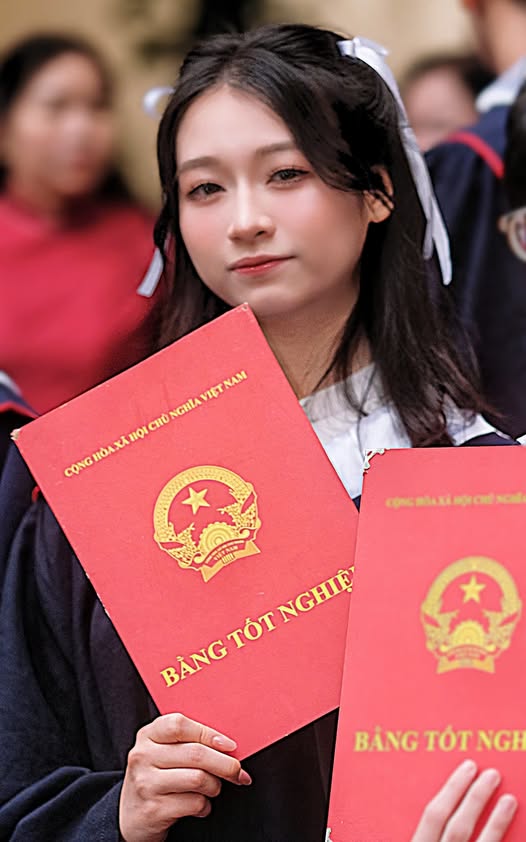 Hoang Huong Giang poses with her diploma at her high school graduation ceremony.