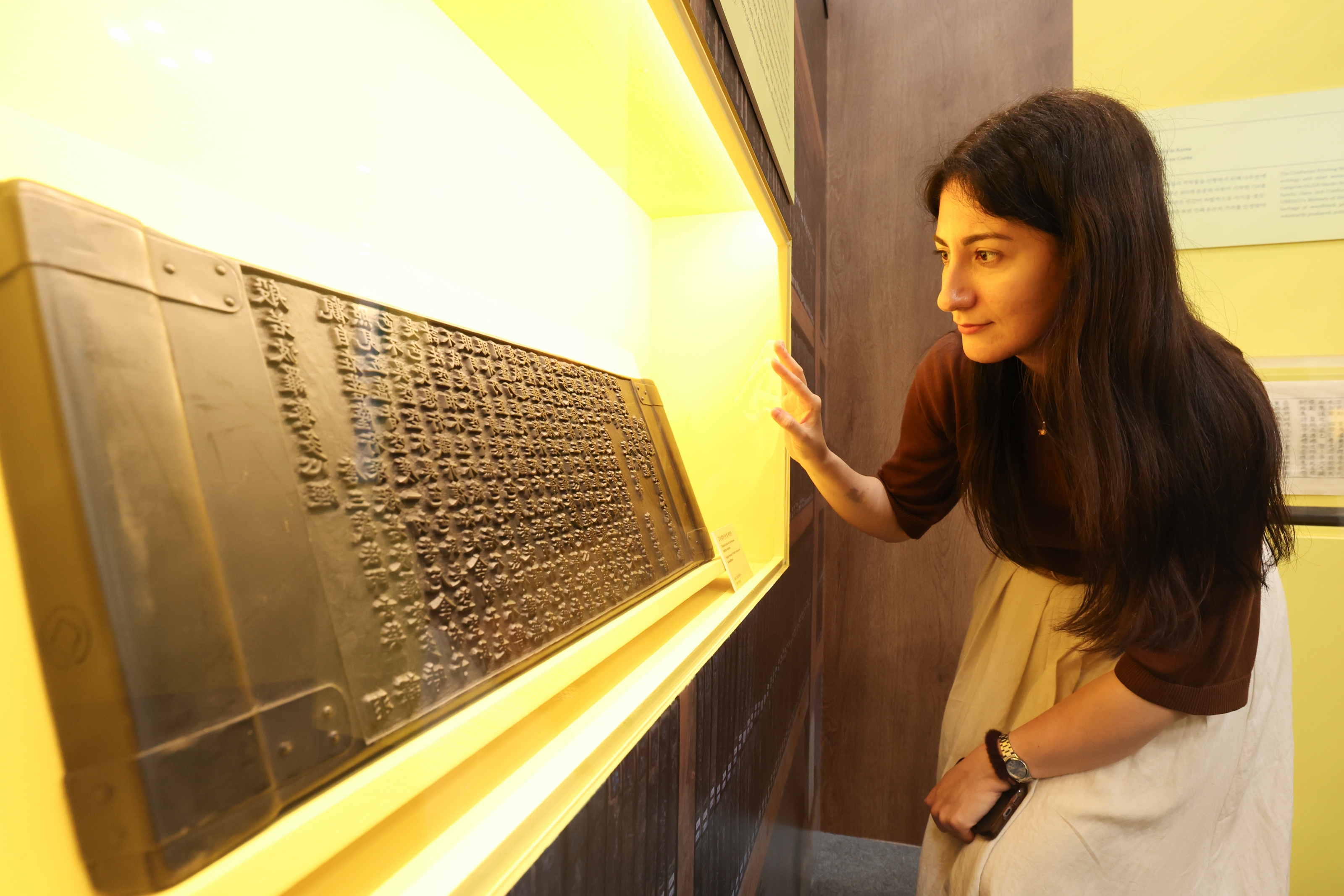 A visitor on July 23 looks at a diplay of the Tripitaka Koreana, a collection of Buddhist texts, at K-Heritage House located at Exhibition Center 1 of the convention complex BEXCO in Busan's Haeundae-gu District.