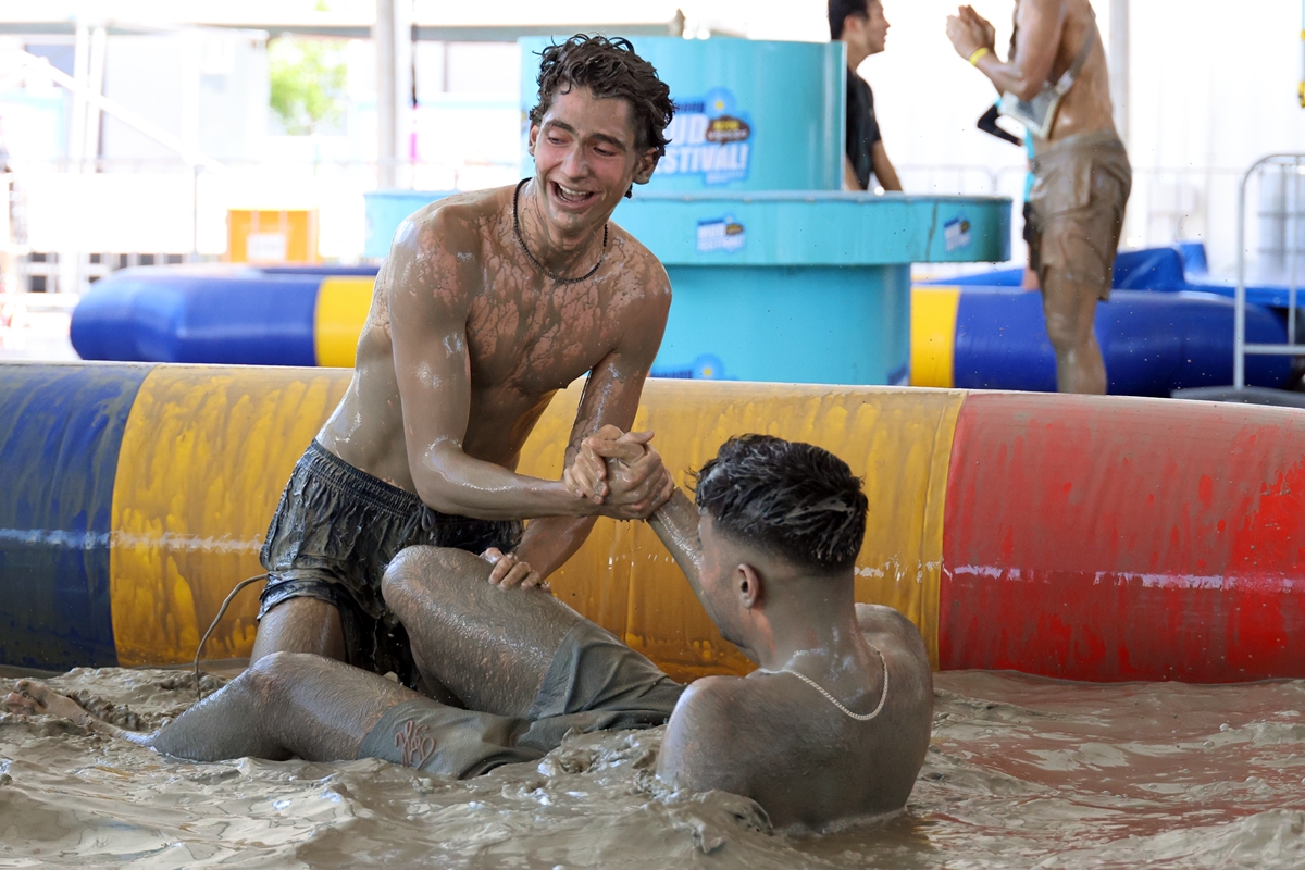 Two visitors on July 24, the opening day of the Boryeong Mud Festival, play in mud at a venue of Daecheon Beach in Boryeong, Chungcheongnam-do Province. (Yonhap News) 
