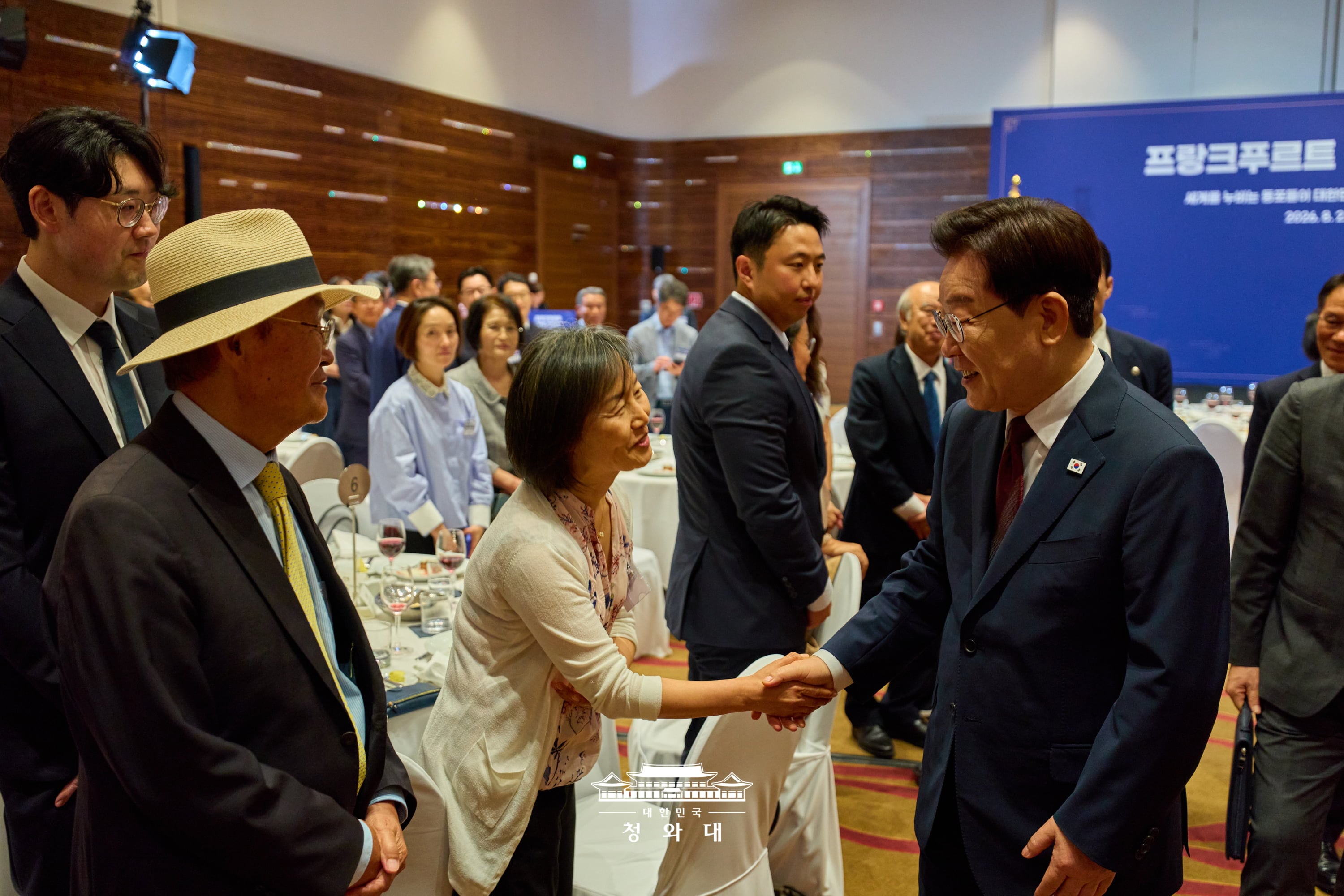 On the final stop of his tour, President Lee on Aug. 2 at a hotel in Frankfurt, Germany, shakes hands with a member of the Korean community there, greeting every attendee individually.