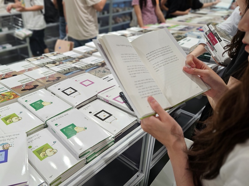 A visitor on Aug. 23 looks at a Minumsa poetry collection featuring collaborations with domestic characters at the pop-up event 