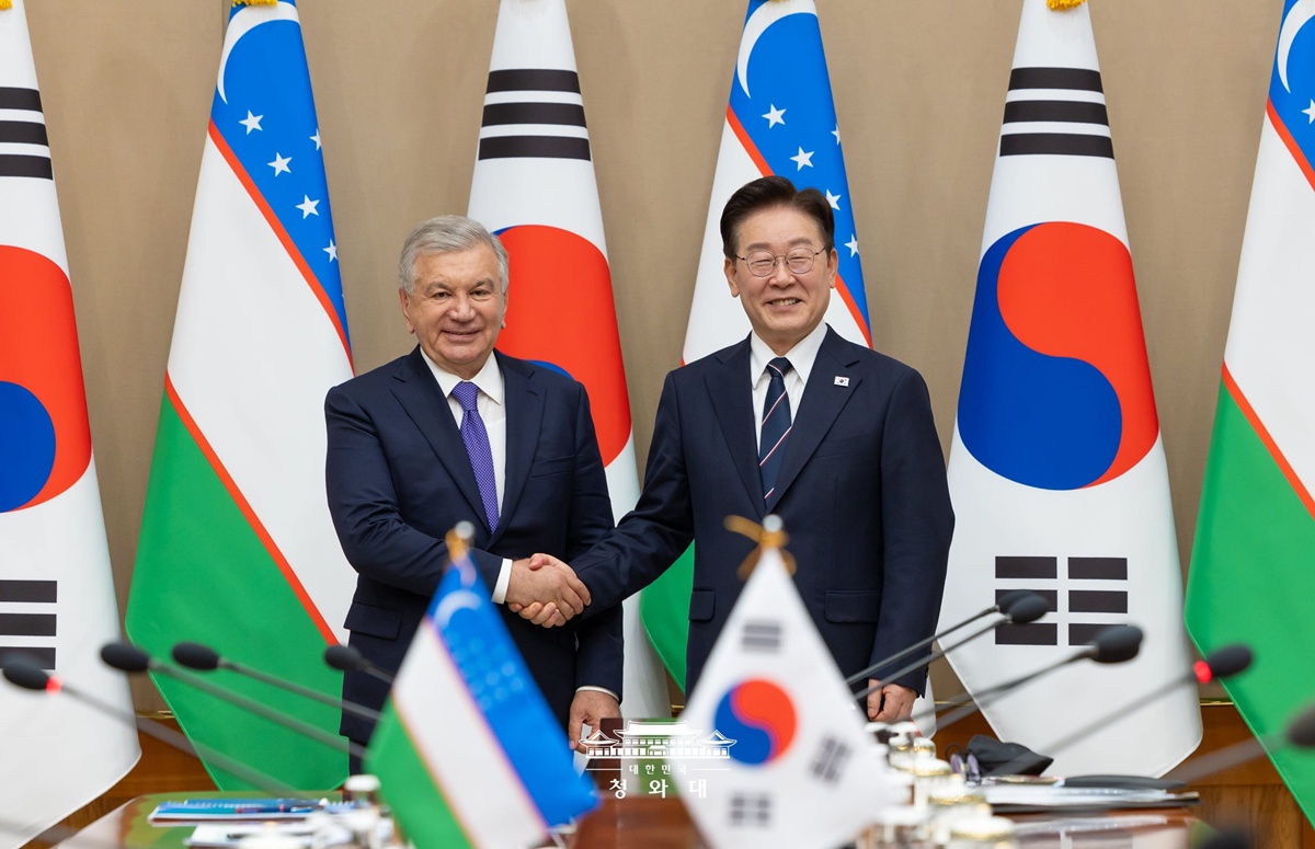 President Lee Jae Myung (right) on Sept. 14 poses for photos with Uzbek President Shavkat Mirziyoyev at Cheong Wa Dae in Seoul. (Cheong Wa Dae)  