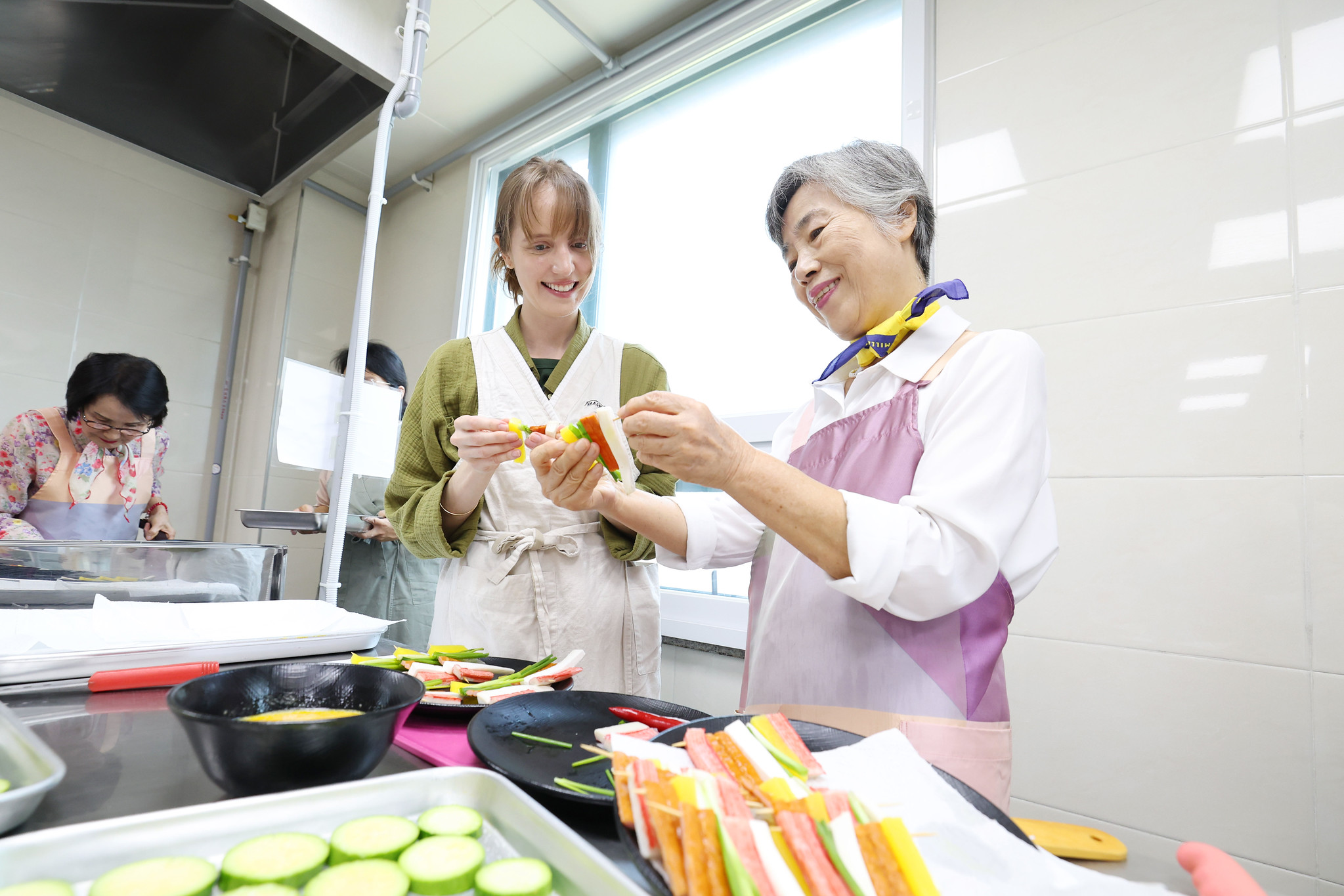 A senior citizen on Sept. 30, 2025, shows a visitor to make traditional holiday dishes together at an international class on Chuseok cooking at the Yongsan Senior Welfare Center in Seoul's Yongsan-gu District. (Korea.net DB) 