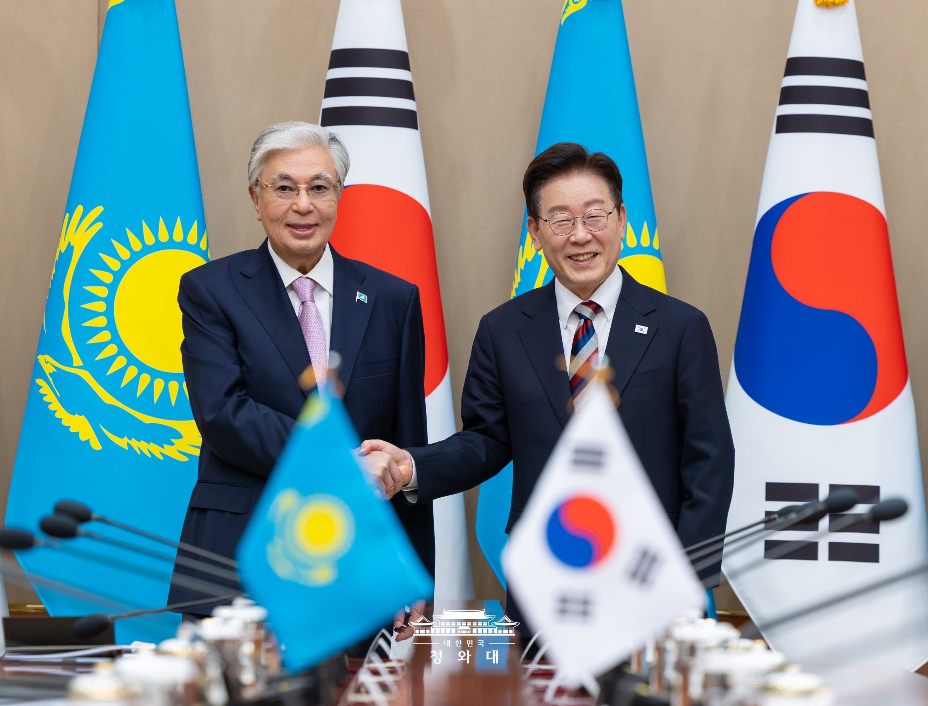 President Lee Jae Myung (right) and Kazakh President Kassym-Jomart Tokayev on Sept. 15 shake hands ahead of their summit at Cheong Wa Dae in Seoul.