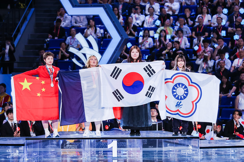 Kim Joyoung (second from right), the gold medal winner in hairdressing, on Sept. 27 holds the national flag at the closing ceremony of this year's WorldSkills Competition at the National Exhibition and Convention Center in Shanghai. (WorldSkills)