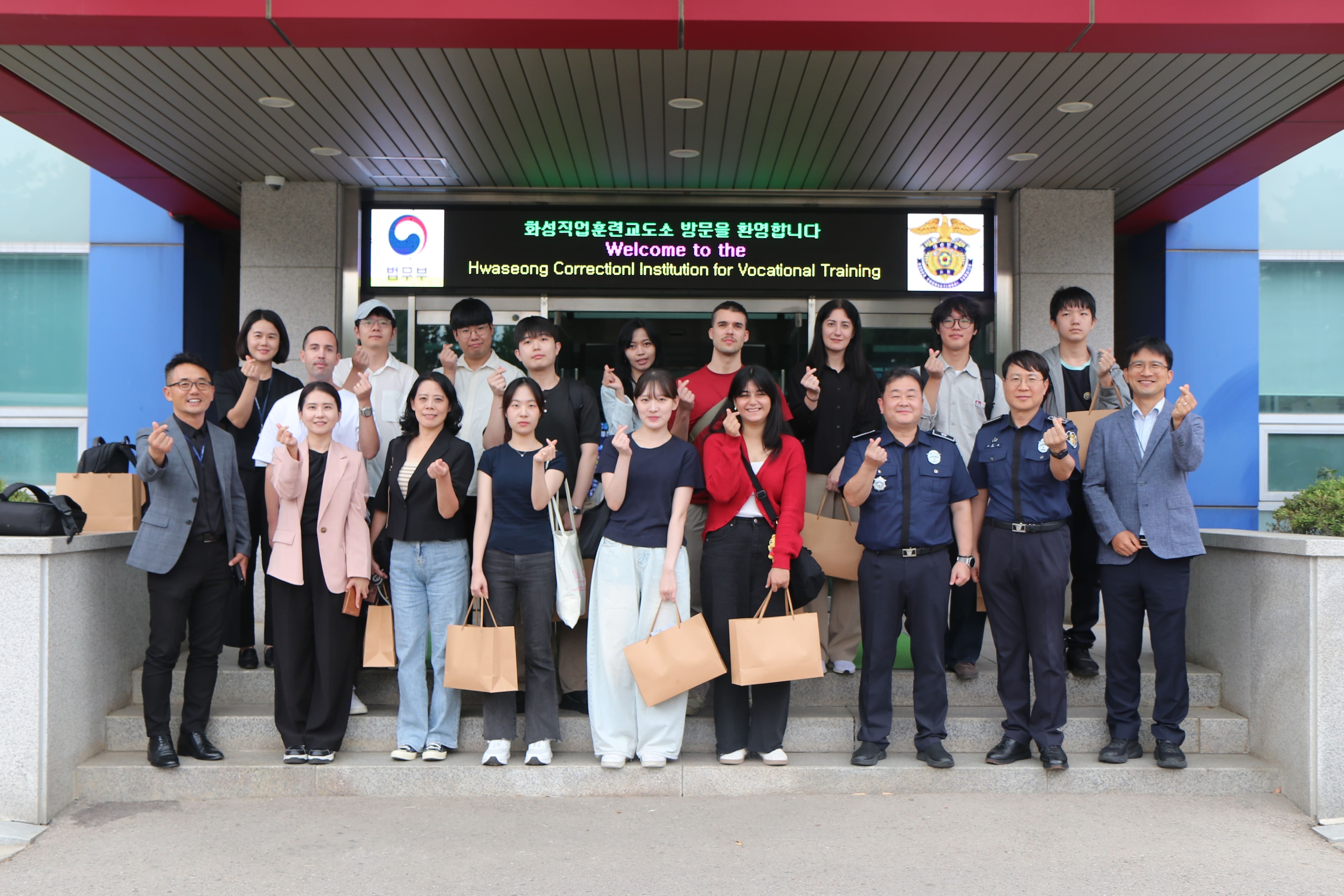 Press tour participants and correctional officials on Sept. 17 pose for a group photo at the entrance of the Hwaseong Correctional Institution for Vocational Training in Hwaseong, Gyeonggi-do. 