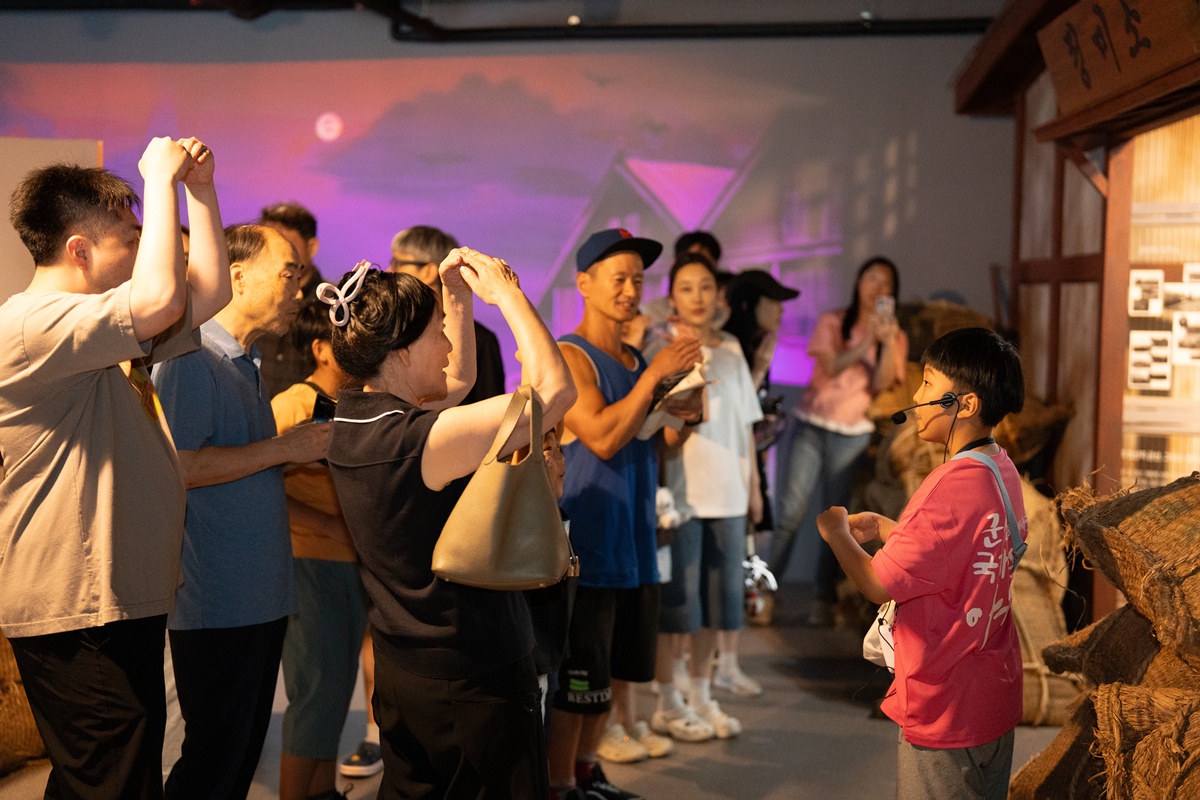 Visitors listen to a boy who is part of the program Children's Heritage Guides of the event 