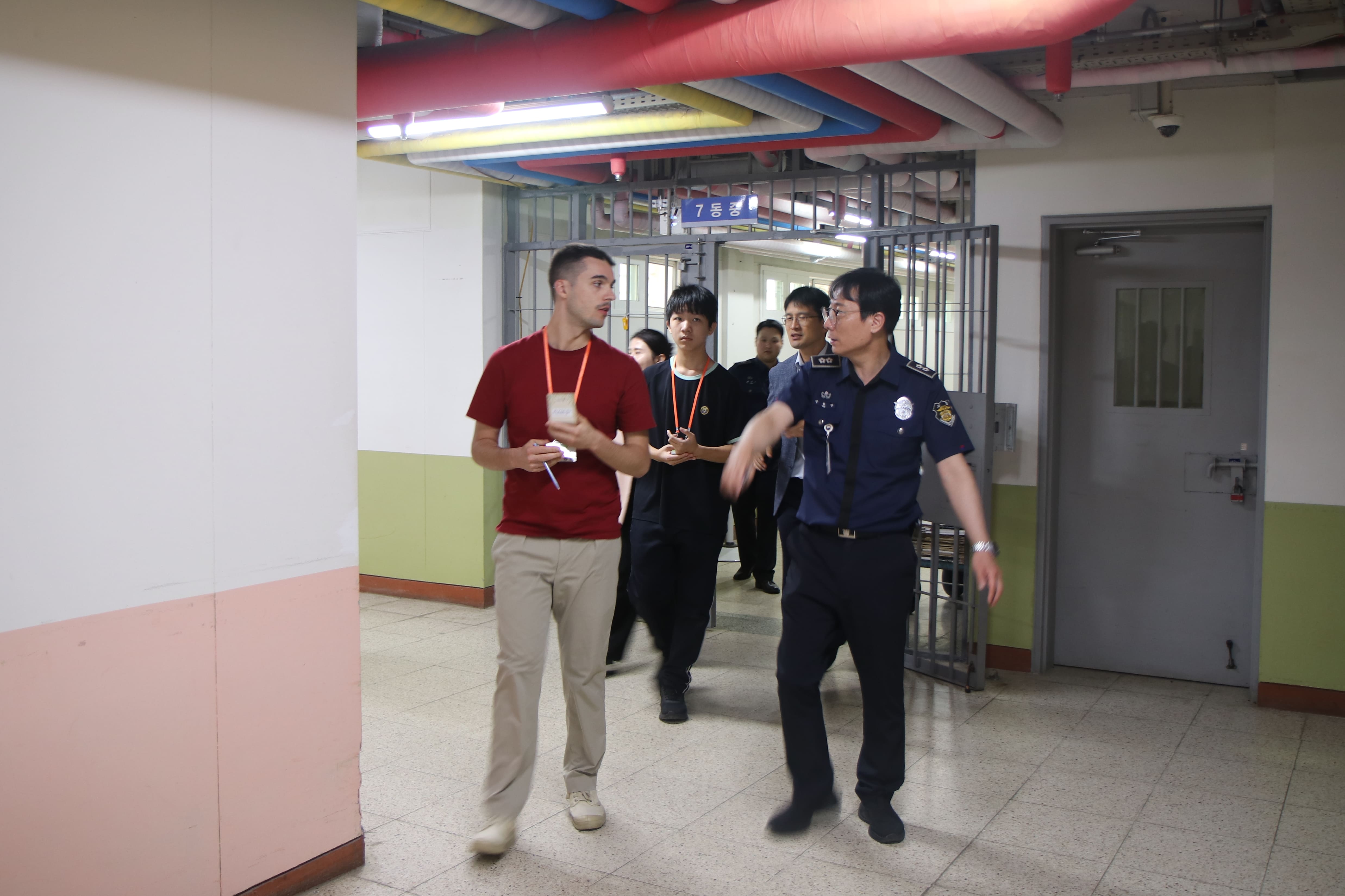 Reporters and a correction officer on Sept.17 walk through a corridor during a facility tour at the Hwaseong Vocational Training Correctional Institution in Hwaseong, Gyeonggi-do.
