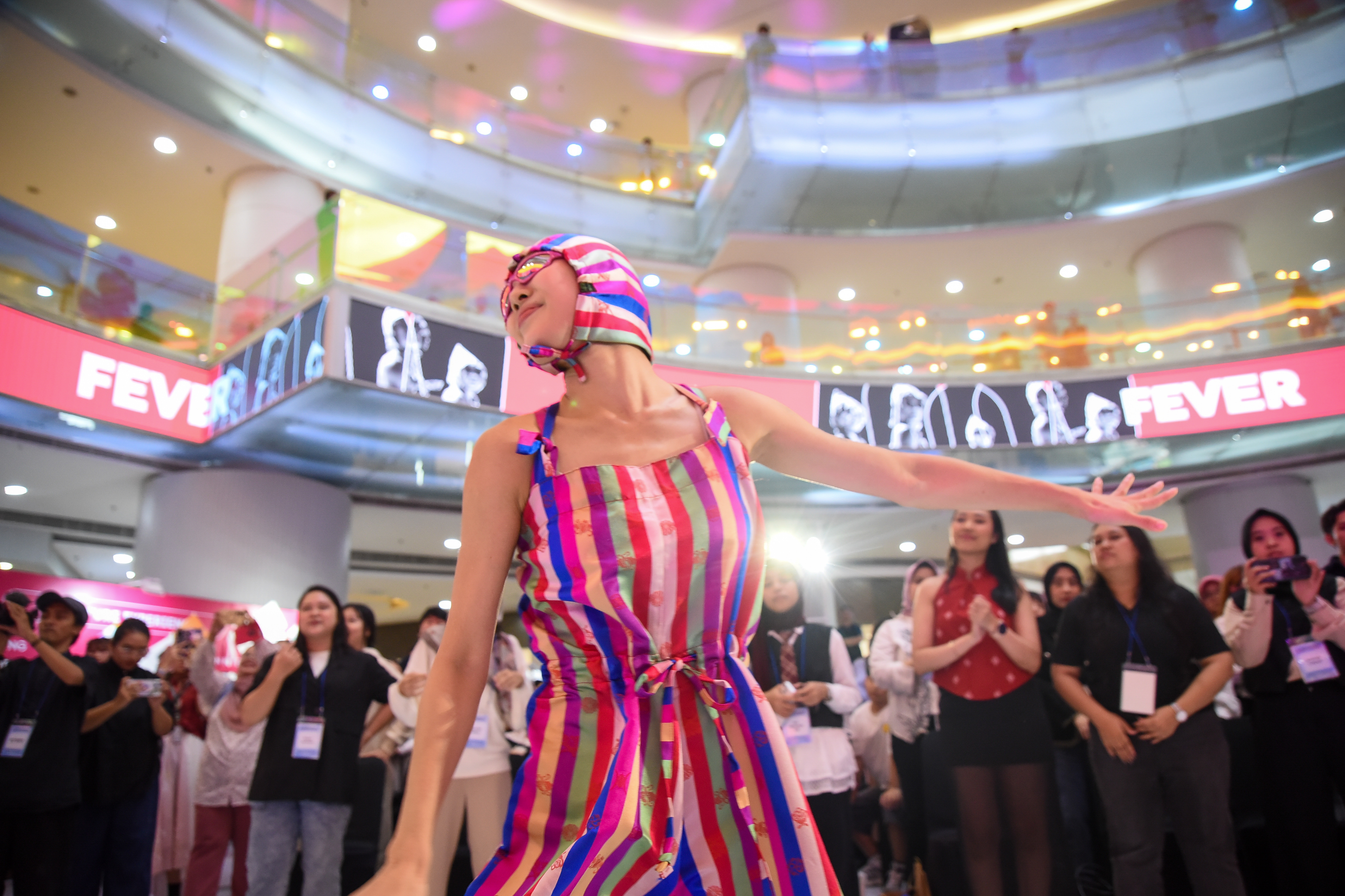 An Ambiguous Dance Company dancer on Oct. 3 performs amid the crowd wearing a colorful outfit featuring saekdong (multi-colored striped) patterns at the main atrium of KOREA 360 in Jakarta. 