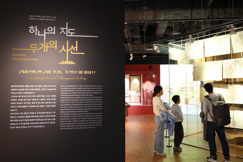 A family on Oct. 16 looks at old Western maps beyond the entrance to the exhibition hall of Dokdo Museum Seoul in Seoul's Yeongdeungpo-gu District, where the Northeast Asian History Foundation's exhibition 