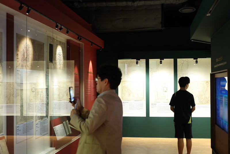 A visitor on Oct. 16 takes a photo of an old map at the exhibition 