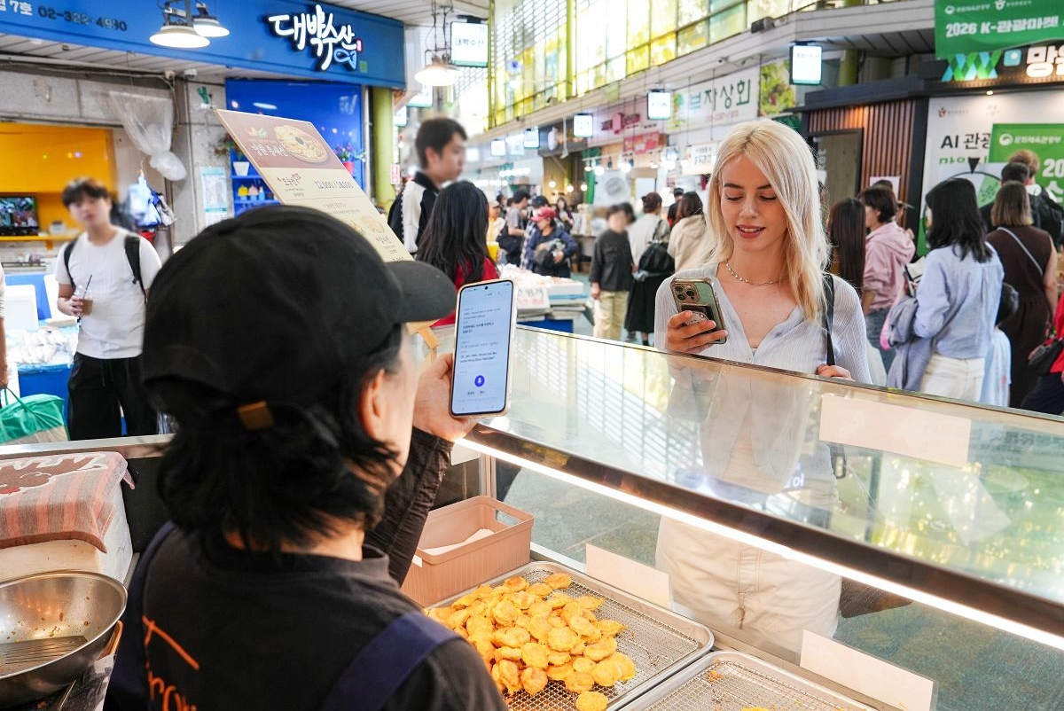 The Ministry of Culture, Sports and Tourism on Oct. 22 in a report said the number of foreign tourists in the first three quarters of this year reached 17.11 million. Shown is a visitor interacting with a merchant at a market using the multilingual translation function of the AI Tourist Butler, an artificial intelligence-powered app. (Korea Tourism Organization)