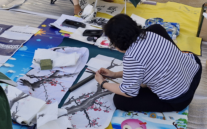 A participant on Oct. 17 creates a traditional-style painting at the 31st Gangdong Prehistoric Culture Festival in Gangdong-gu District, Seoul. (Faranak Solat)