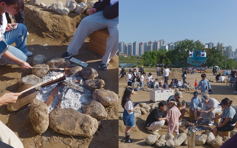 Families and visitors on Oct. 17 gather around stone-lined fire pits for fire-making and marshmallow roasting at the 31st Gangdong Prehistoric Culture Festival in Gangdong-gu District, Seoul. (Gangdong-gu District Office)