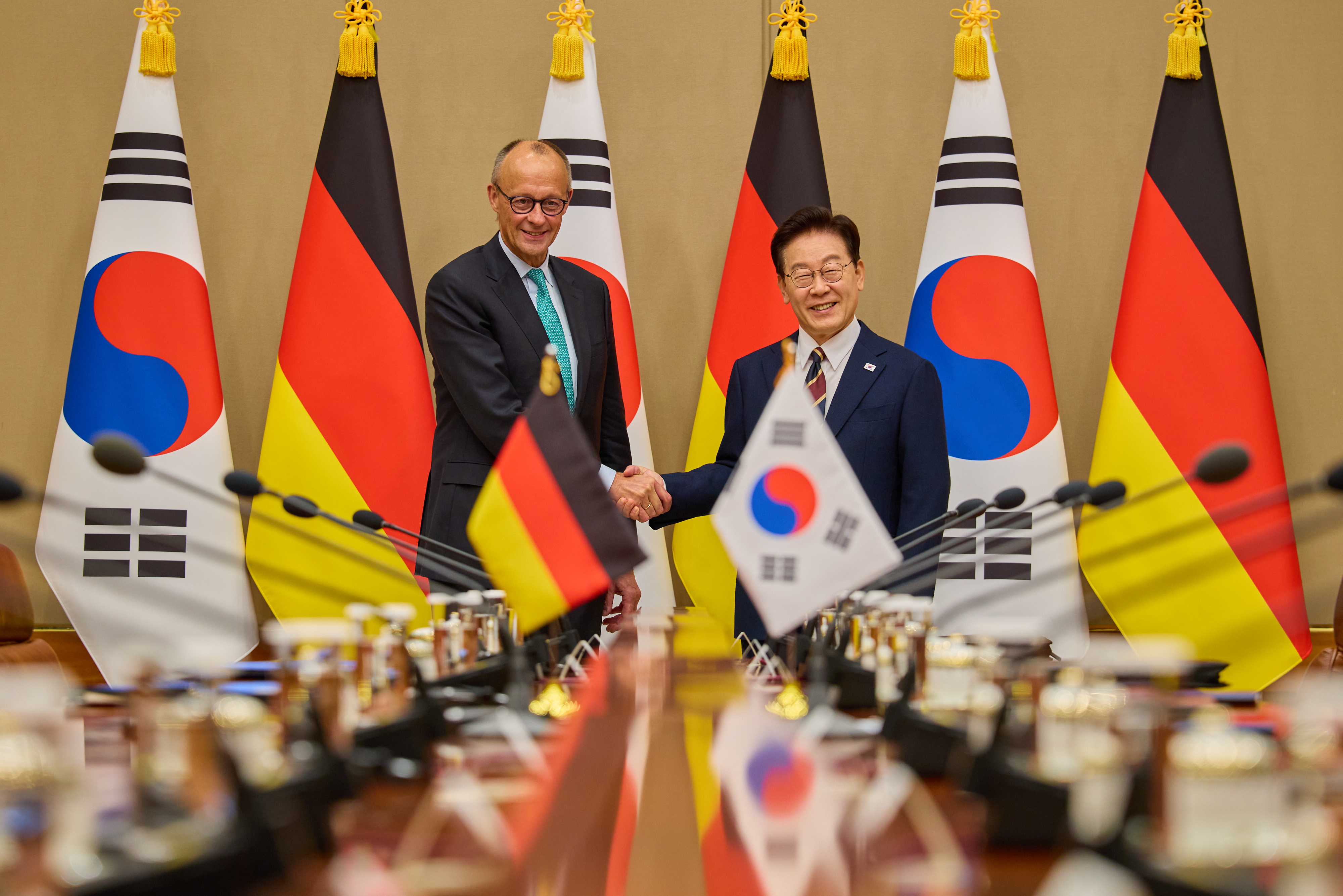 President Lee Jae Myung (right) and German Chancellor Friedrich Merz on Oct. 29 shake hands ahead of their expanded bilateral summit at Cheong Wa Dae in Seoul.
