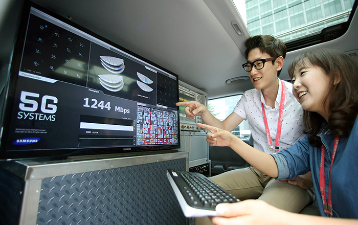 Samsung Electronics staff members smile after successfully demonstrating the company's 5G wireless system inside an express bus running at speeds higher than 100 kilometers per hour. (photo courtesy of Samsung Electronics)