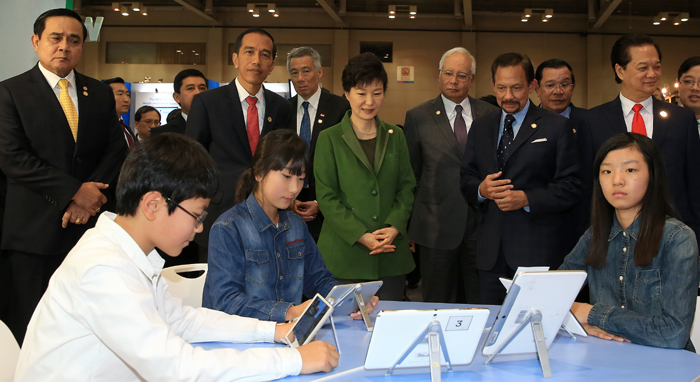 President Park Geun-hye (center) and leaders from the 10 ASEAN countries visit a booth that features a 'smart classroom' at an exhibition on innovation in public administration held at the BEXCO center in Busan on December 12. 
