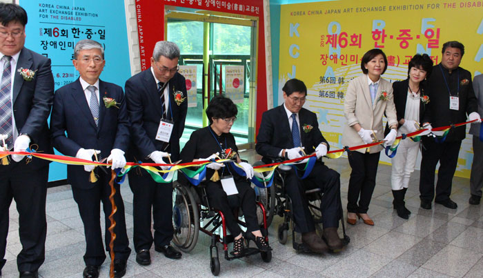 Dignitaries cut the ribbon during the opening ceremony for the Korea, China, Japan Art Exchange Exhibition on June 23.