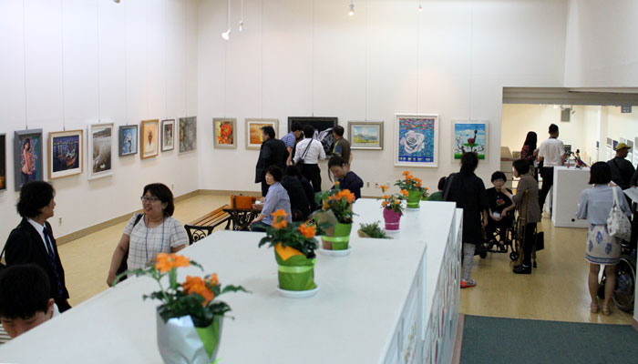 Visitors appreciate the works of art on display at the Korea, China, Japan Art Exchange Exhibition.