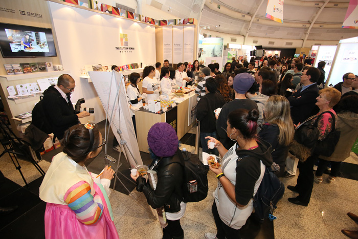  (Top) Son Jung-soo, known as João Son in Brazil, introduces Korean foods to a Brazilian local. (Bottom) A Korean food tasting event attracts many visitors. (photos courtesy of Korean Creative Content Agency) 
