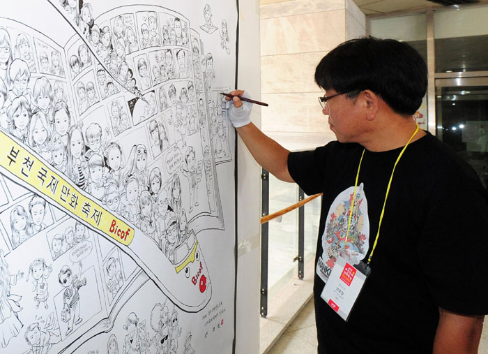 Cartoonist An Jung-geol completes one of his drawings at the Bucheon International Comics Festival.