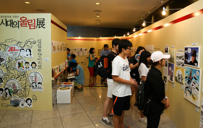 Comic fans inspect the drawings on display in a special exhibit at the Bucheon International Comics Festival.